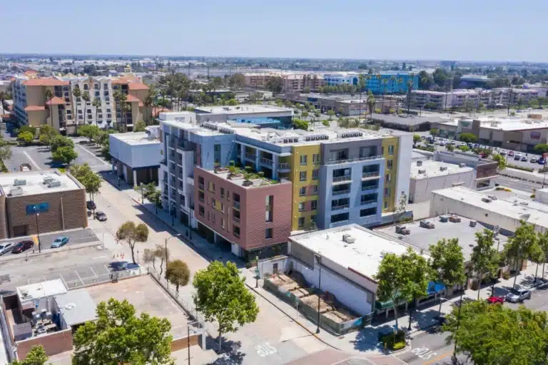 Modern apartment buildings in downtown Downey, California, highlighting Haven House’s virtual sober living services in the area.