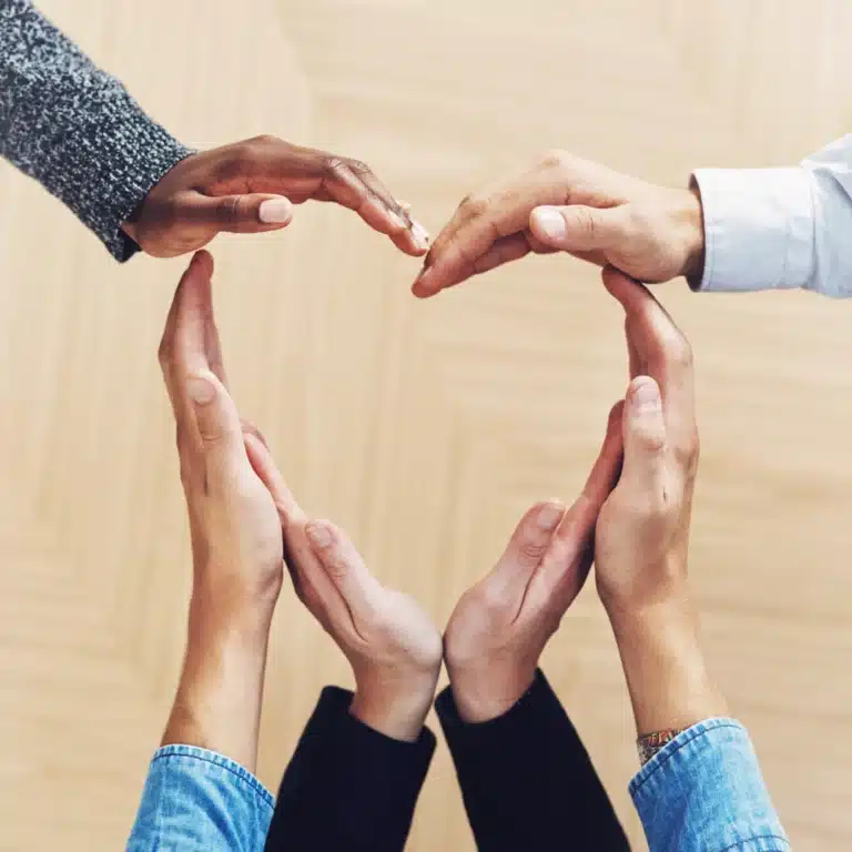 Group of diverse hands forming a heart shape together, symbolizing support, unity, and compassion for a loved one facing addiction and recovery challenges.